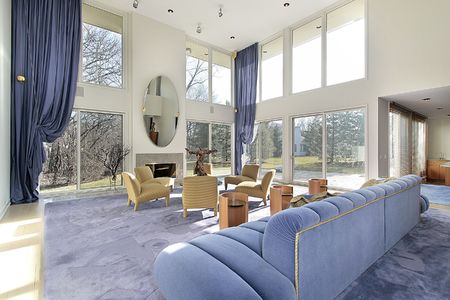 Family room in luxury home with two story windowsの写真素材