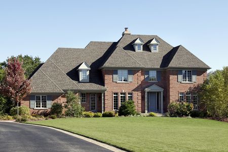 Large brick home with arched entry and blue doorの写真素材