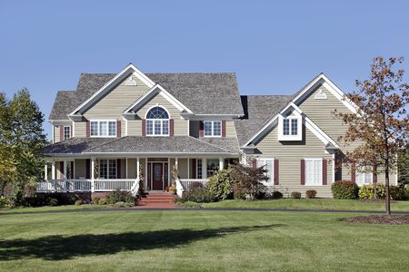 Large suburban home with front porch and cedar roofの写真素材