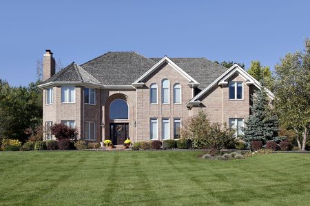 Large brick home in suburbs with arched entryの写真素材
