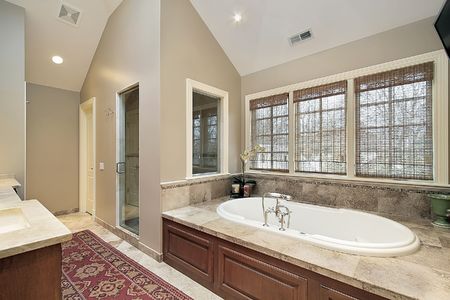 Master bath in luxury home with wood paneled tubの写真素材