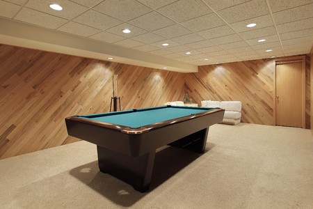 Pool table in suburban home with wood paneling