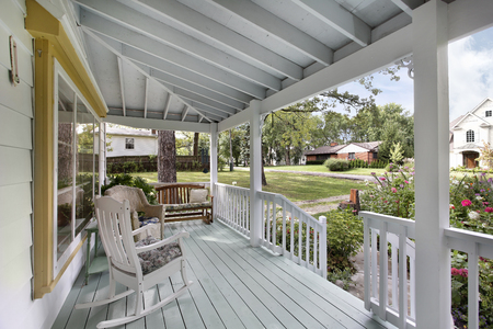 Front porch on suburban home with rocking chair and bench.の写真素材