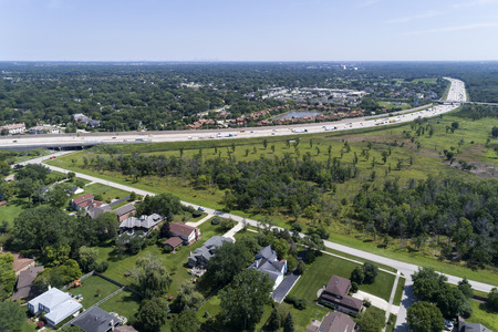 Aerial view a highway beside a nature area and housing developments in suburban Chicago.の写真素材