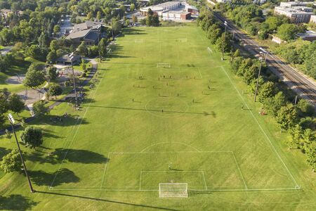 Aerial view of a soccer game in progress in a suburban setting.の写真素材