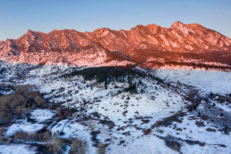 Aerial photo of the Boulder, Colorado foothills near Eldorado Canyon just after sunrise in winter following an overnight snowfall.の写真素材