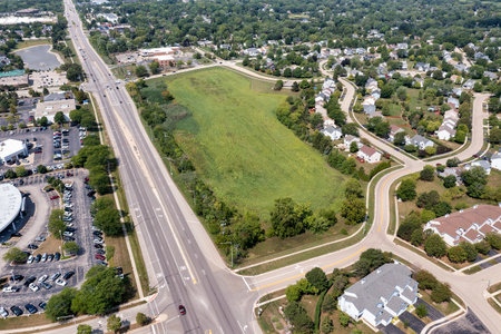 A aerial showing a parcel of land for sale near a housing development and retail shopping center in a suburban area.の写真素材