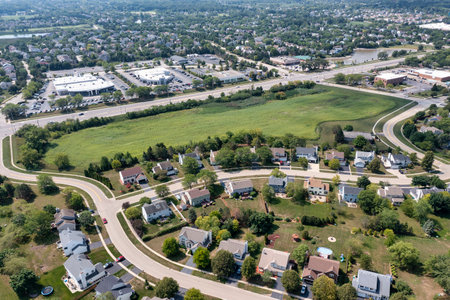 A aerial showing a parcel of land for sale near a housing development and retail shopping center in a suburban area.の写真素材