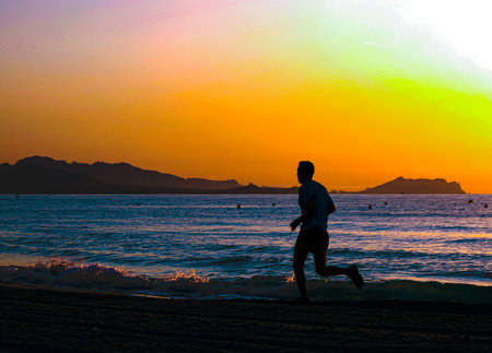 Man running on the beach at sunrise. Healthy lifestyle conceptの写真素材
