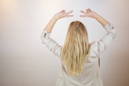 Woman backwards with victory gestureの写真素材