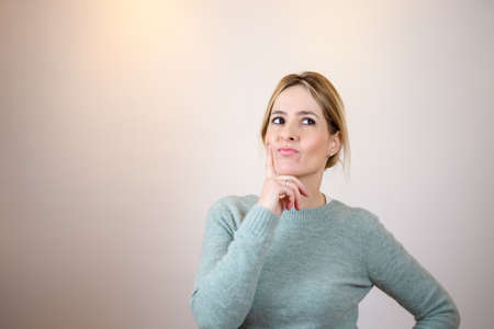 Woman thinking with finger on chin