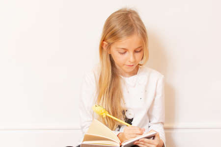 Girl writing in a notebook with long hairの写真素材