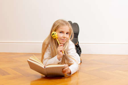 Blond little girl reading a book