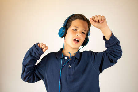Smiling young boy listening to musicの写真素材