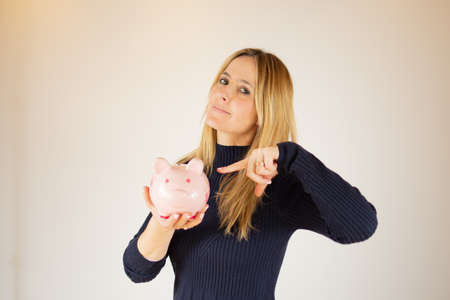 Young woman with a piggy bank in her hand