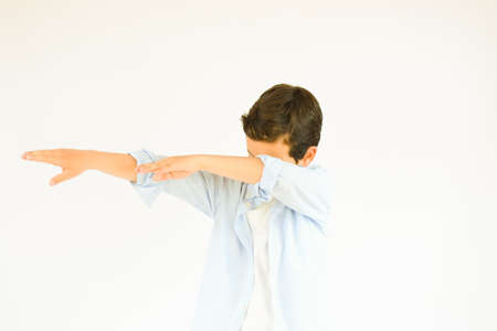 Boy with blue shirt making dab gesture