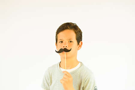 Young happy boy making mustache gesture