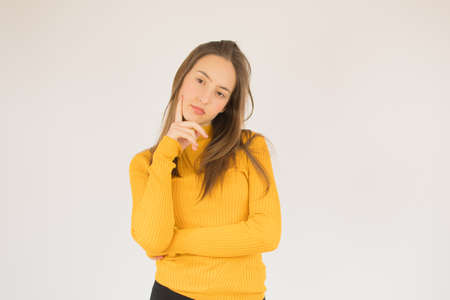 Beautiful young girl with yellow shirt thoughtful