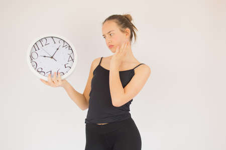 Young beautiful girl with big clock