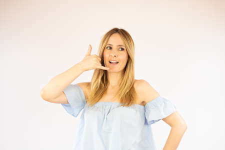 Beautiful woman in casual clothes making the gesture of calling on the phone