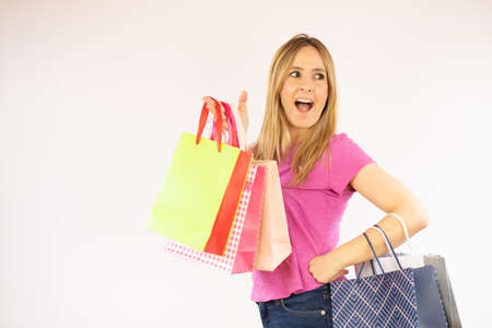 Pretty shopping woman in pink shirt with bags in hand