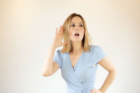 Young pretty woman wearing blue dress and making listening gesture