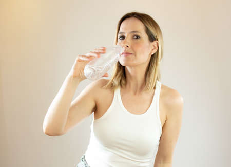 Beautiful woman making gesture of drinking waterの写真素材