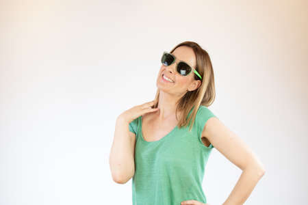 Beautiful woman laughing with glasses and green shirtの写真素材