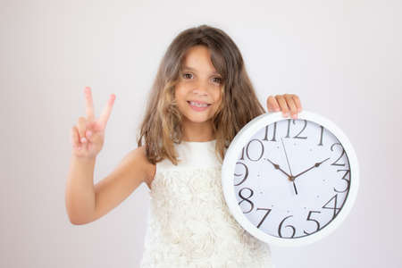 Beautiful girl smiling showing a clockの写真素材