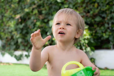 Beautiful blond baby very happy and smiling in the poolの写真素材