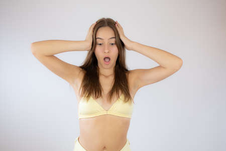 Pretty young girl in bikini making surprise gestureの写真素材