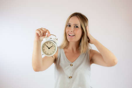 Young woman with short hair and casual dress showing a clockの写真素材
