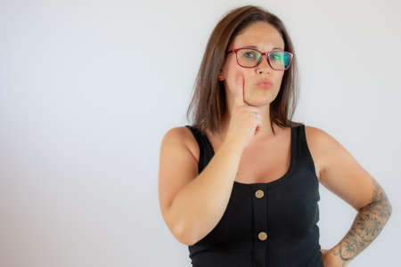 Beautiful young woman in black shirt with doubtful gesture