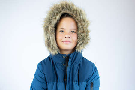 Portrait of a smiling handsome boy in a fur hooded coatの写真素材