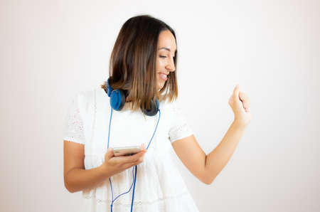 Beautiful woman in white dress with headphones
