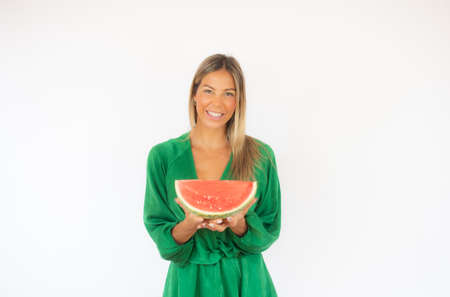 Beautiful woman in green dress with a watermelon smilingの写真素材
