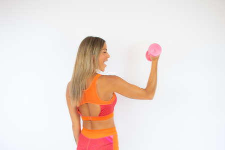 Smiling athlete woman with a dumbbell on white background