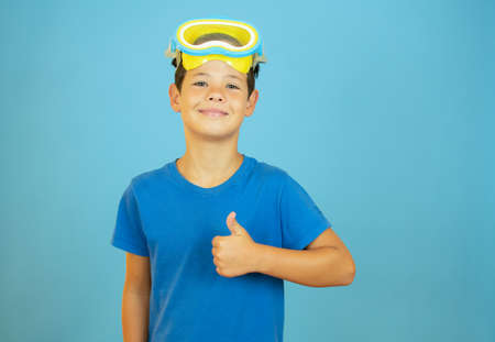 Boy with diving goggles smiling with thumb up