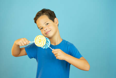 Smiling boy with lollipops in hand