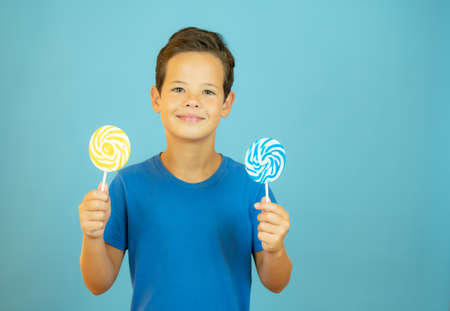 Smiling boy with lollipops in handの写真素材