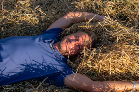 Man in blue shirt lying on the strawの写真素材