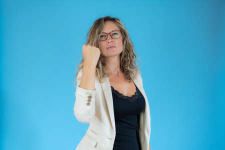 Business woman with a triumphant gesture on blue background