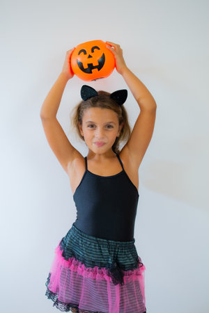 funny child girl in witch costume for Halloween over cobweb backgroundの写真素材