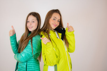 Two smiling friends in winter jackets on white backgroundの写真素材
