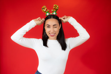 Portrait of a happy young woman holding paper heart isolated over red backgroundの写真素材
