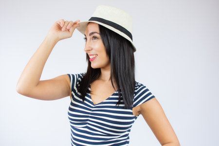 Beautiful young business woman holding digital tablet and looking at camera with smile while standing over white background.の写真素材