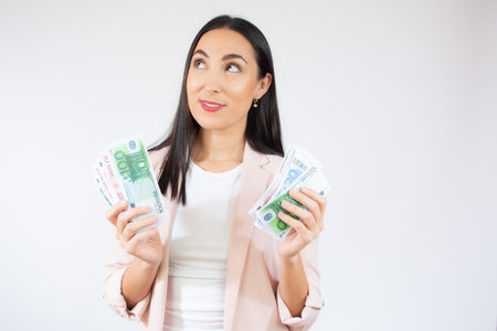 Portrait of a happy young woman holding paper heart isolated over red backgroundの写真素材