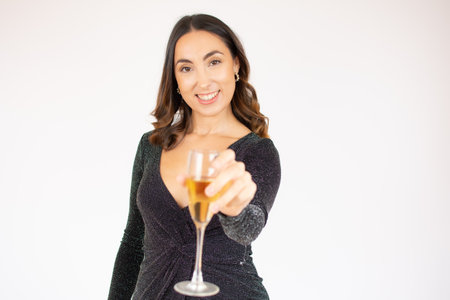 Happy New Year to you. One young and beautiful woman dancing with glass of champagne and smiling. Woman is happy about the New Yearの写真素材