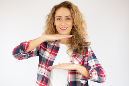Middle age woman over isolated background holding something with both hands, product presentation.の写真素材