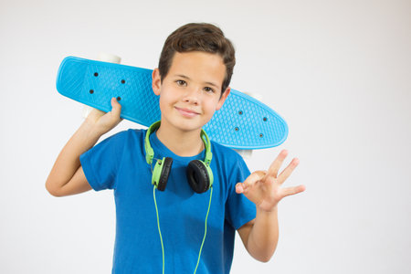 Full length portrait of an adorable young boy riding a skateboard isolated against white background